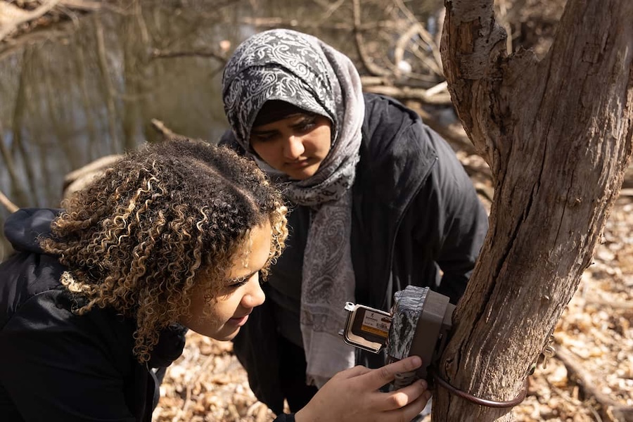 Two biology students checking on a camera trap