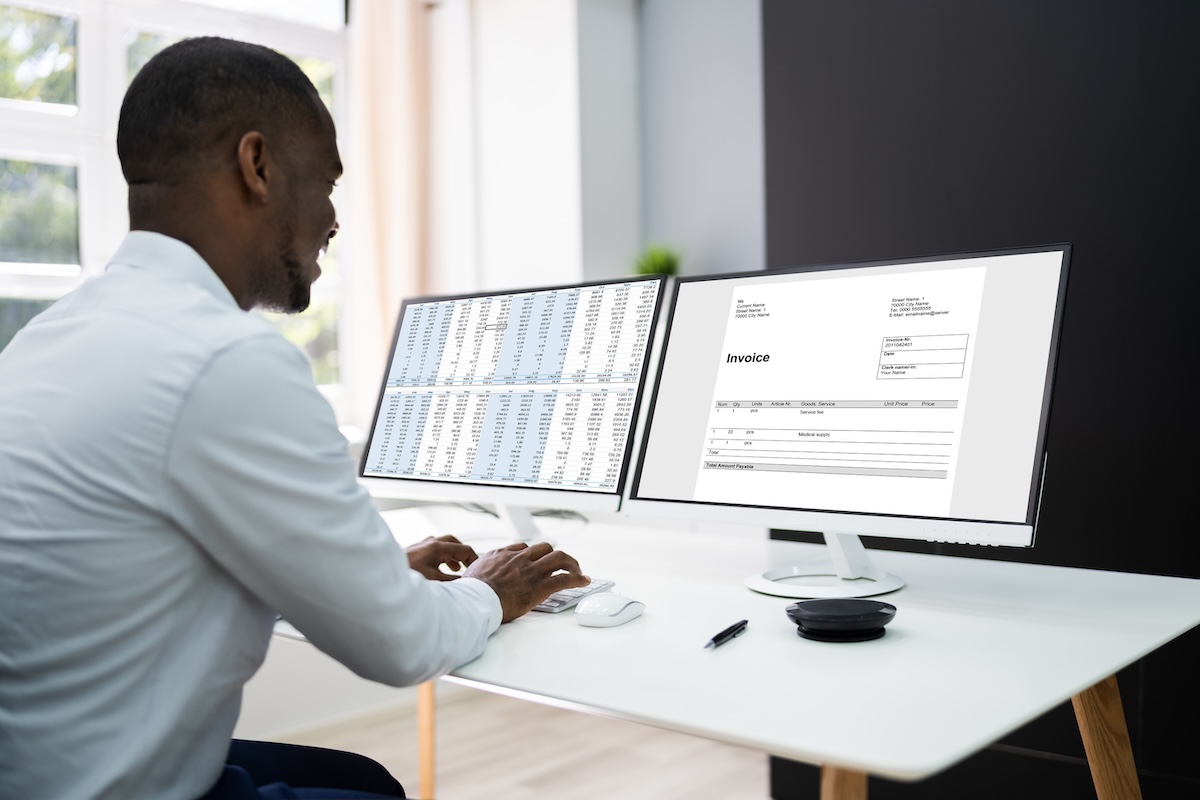 Man working on financial documents on his computer